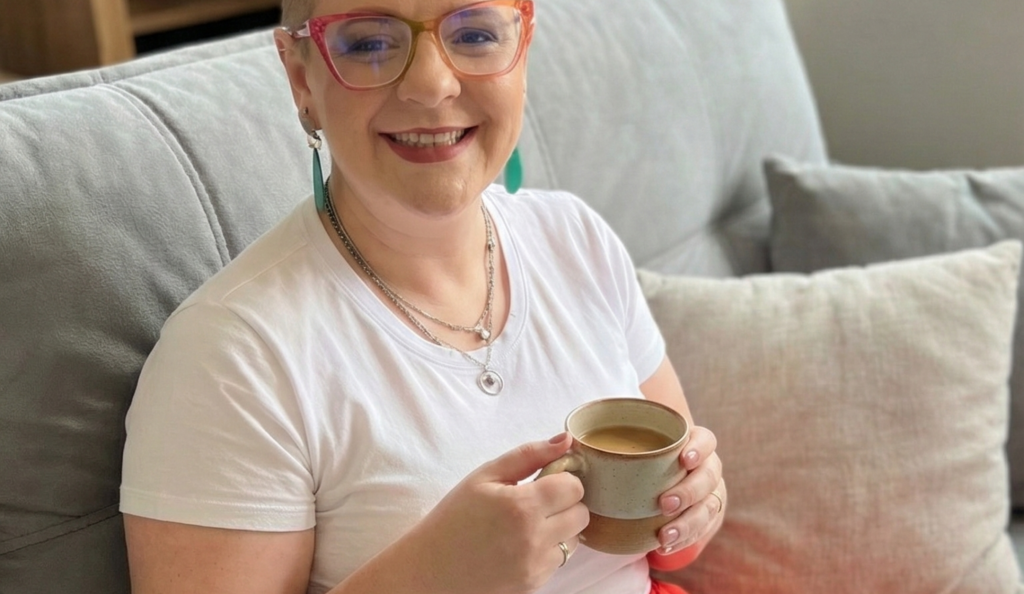 Mulher empreendedora analisando métricas que importam no notebook de forma tranquila e sorrindo.