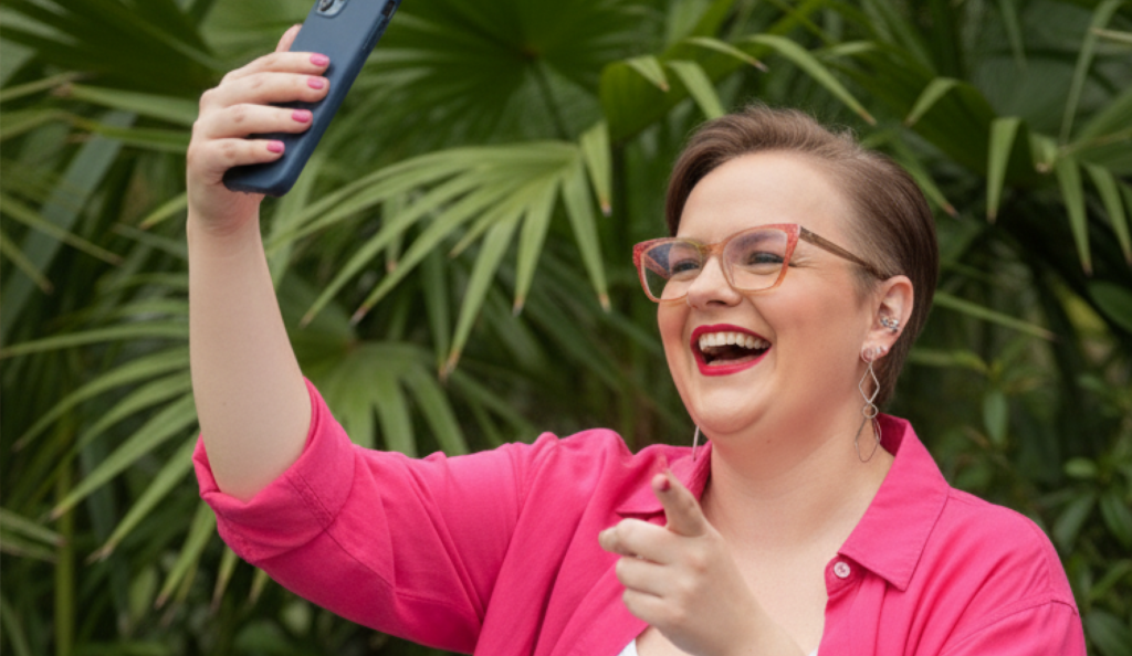 Empreendedora sorrindo com confiança demonstrando um bom posicionamento no Instagram através da sua imagem pessoal.